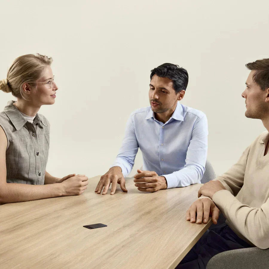 Tres personas conversando en una mesa