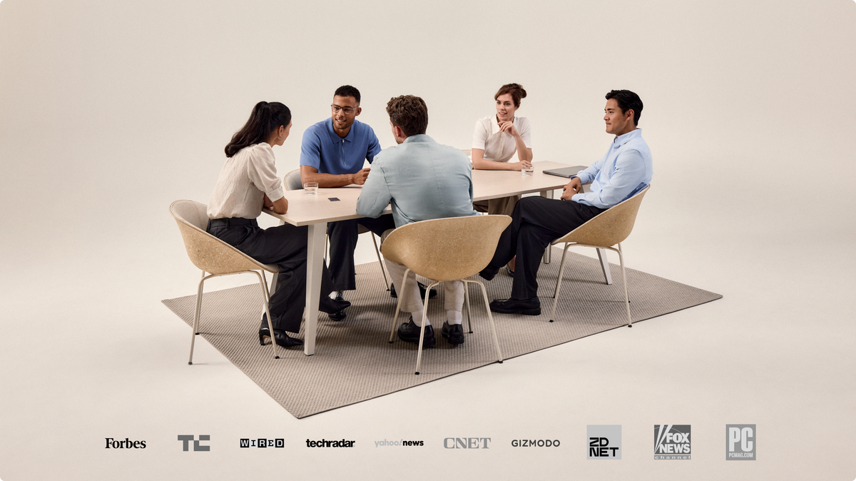 Grupo de cinco personas en una reunión, con un Plaud AI voice recorder en la mesa y logos de medios.