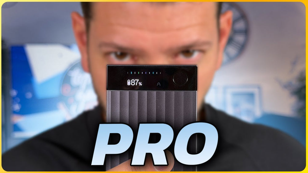 Hombre sosteniendo un Plaud Note Pro gris oscuro con pantalla mostrando 87% de batería, cubriendo parcialmente su rostro.