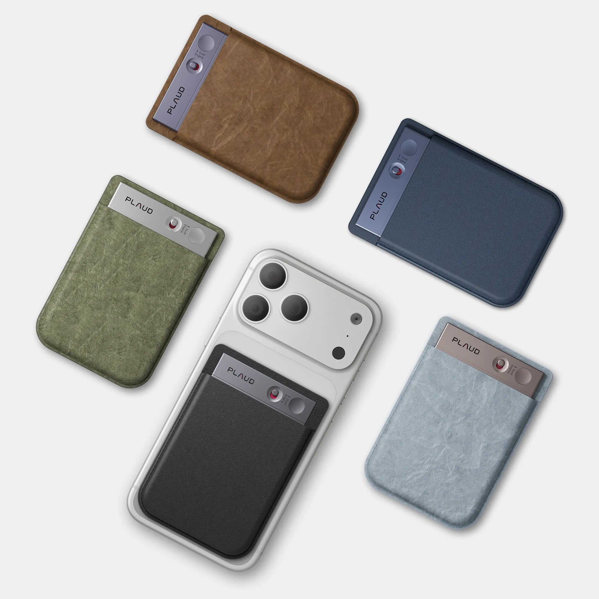 Varios Plaud Note en colores marrón, verde oliva, azul marino, azul claro y negro, algunos acoplados a una funda de teléfono.